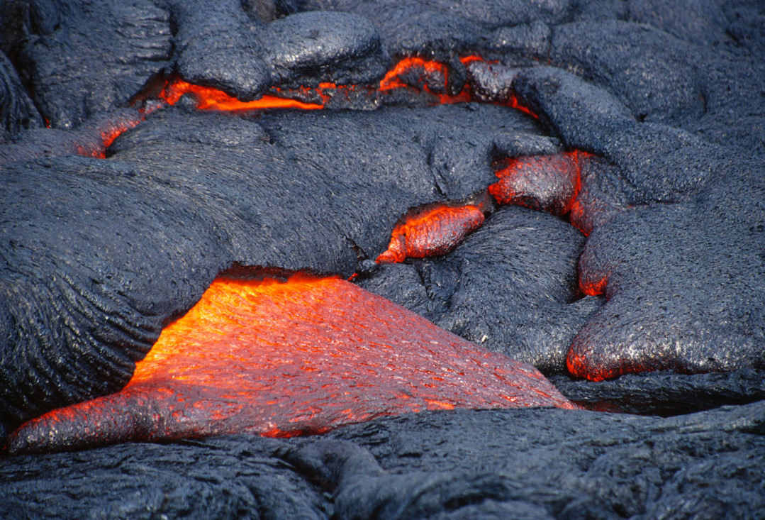 Afkoelende lava. De grijze lava heeft al een korst, de oranjegele lava is nog heet en vloeibaar.